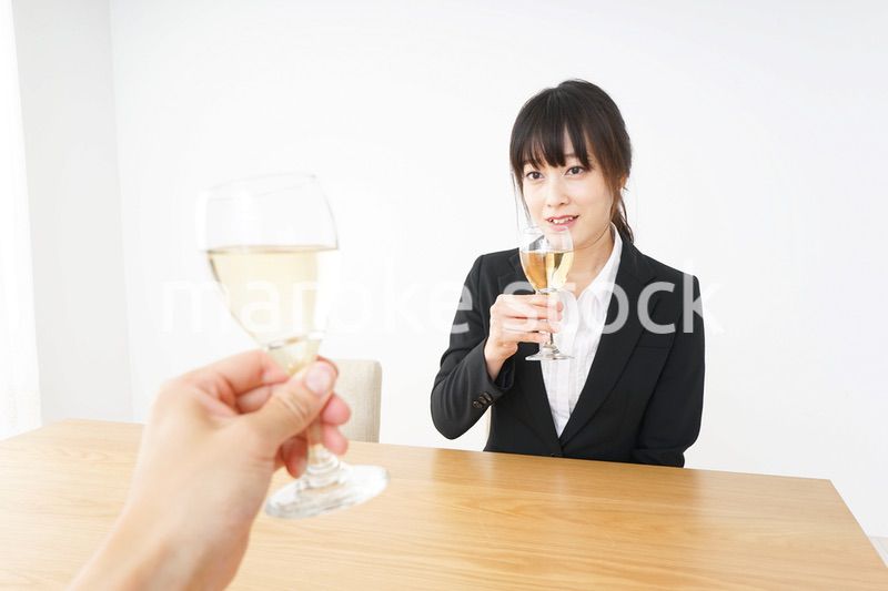 スーツ姿でお酒を飲む若い女性