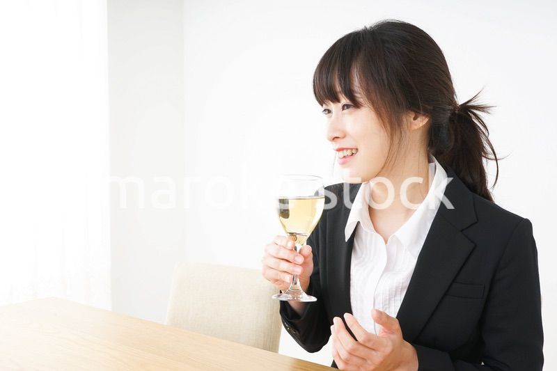 スーツ姿でお酒を飲む若い女性