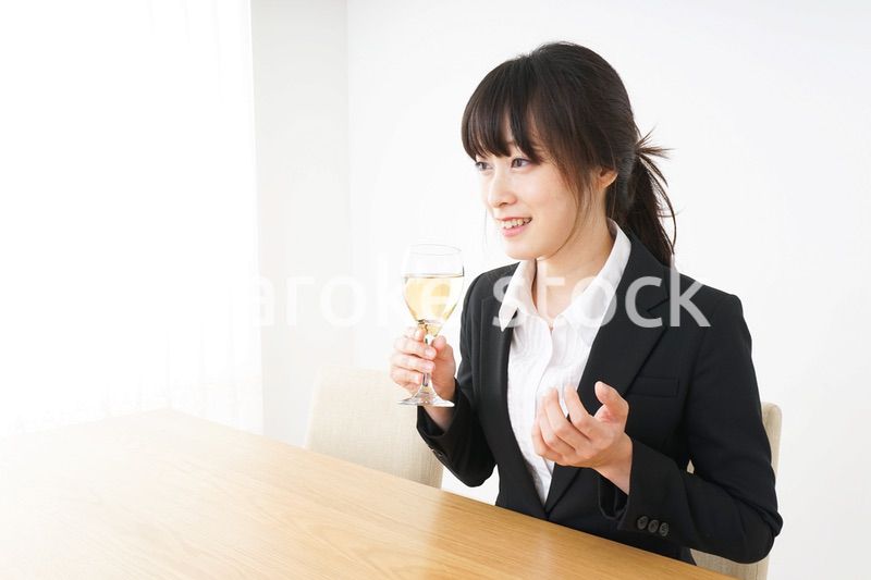 スーツ姿でお酒を飲む若い女性