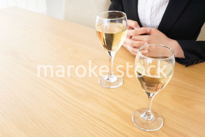 スーツ姿でお酒を飲む若い女性