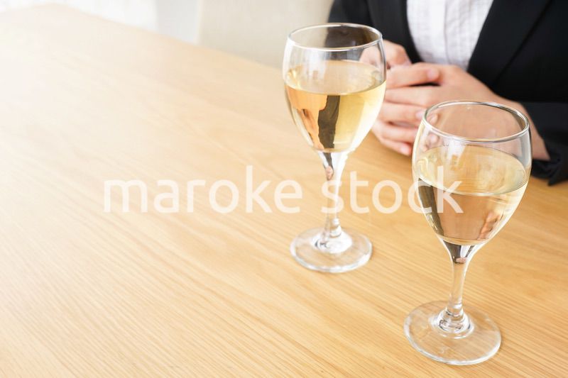 スーツ姿でお酒を飲む若い女性