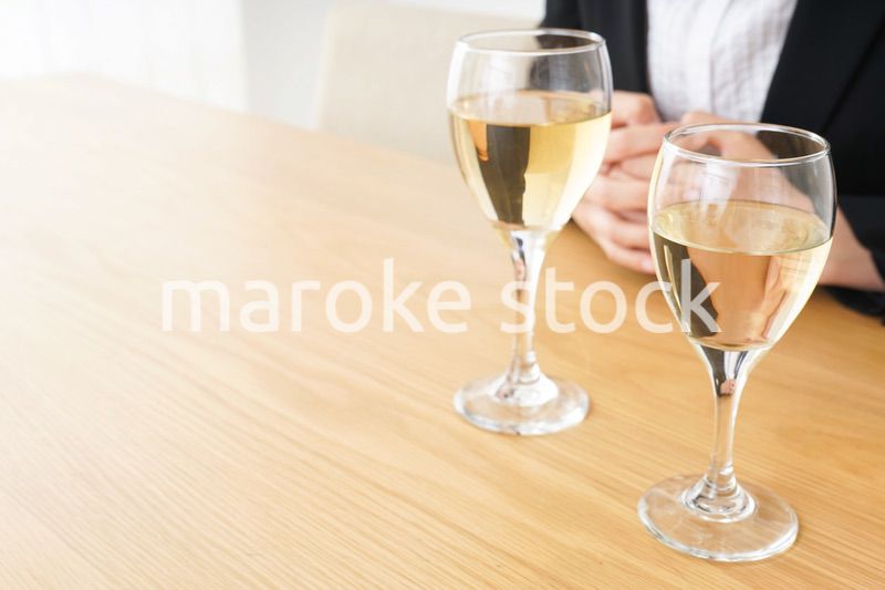 スーツ姿でお酒を飲む若い女性