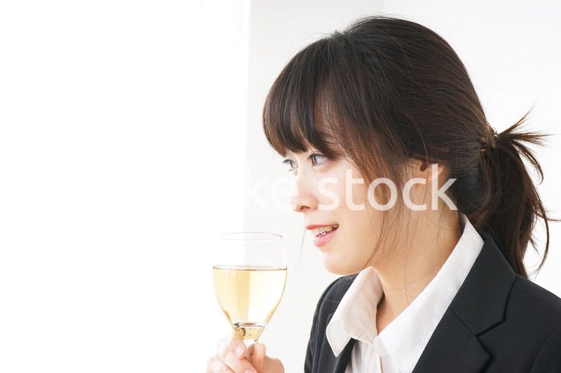 スーツ姿でお酒を飲む若い女性