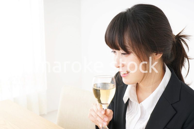 スーツ姿でお酒を飲む若い女性