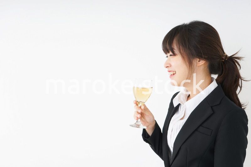 スーツ姿でお酒を飲む若い女性