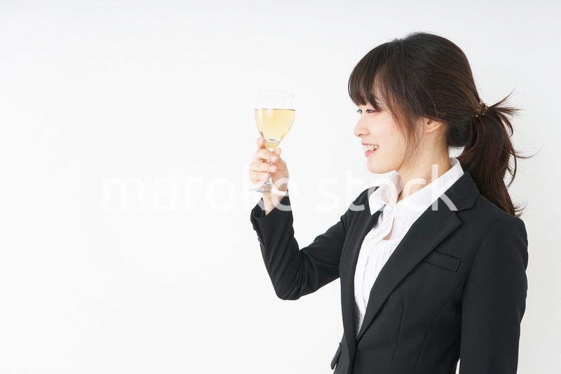 スーツ姿でお酒を飲む若い女性
