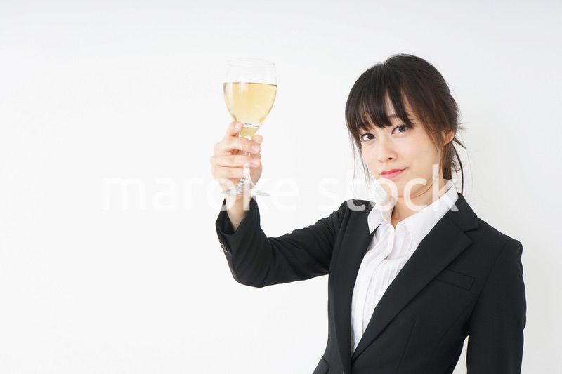 スーツ姿でお酒を飲む若い女性
