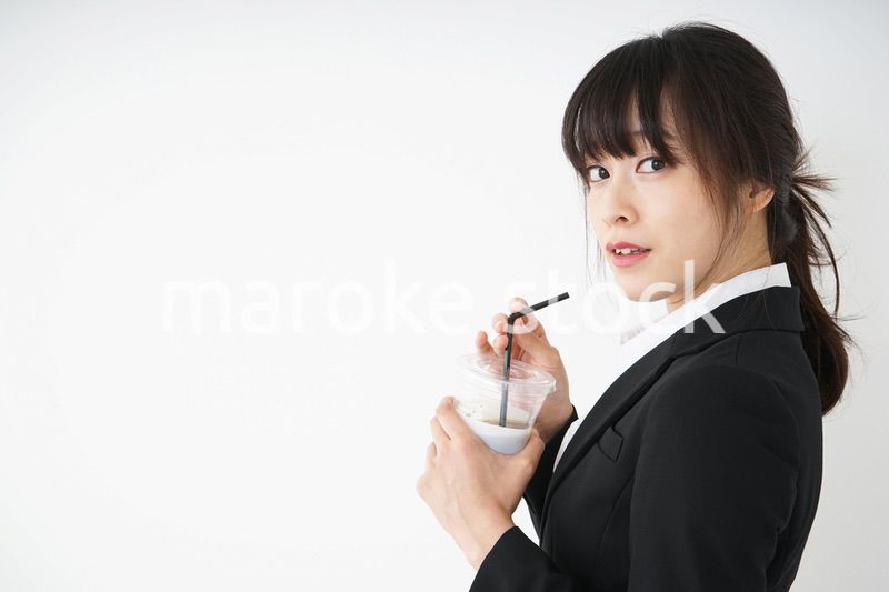 オフィスでアイスコーヒーを飲む若いビジネスウーマン