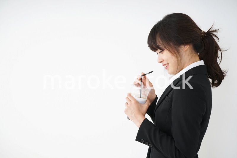 オフィスでアイスコーヒーを飲む若いビジネスウーマン