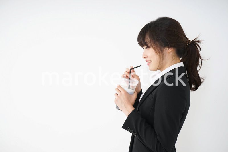 オフィスでアイスコーヒーを飲む若いビジネスウーマン