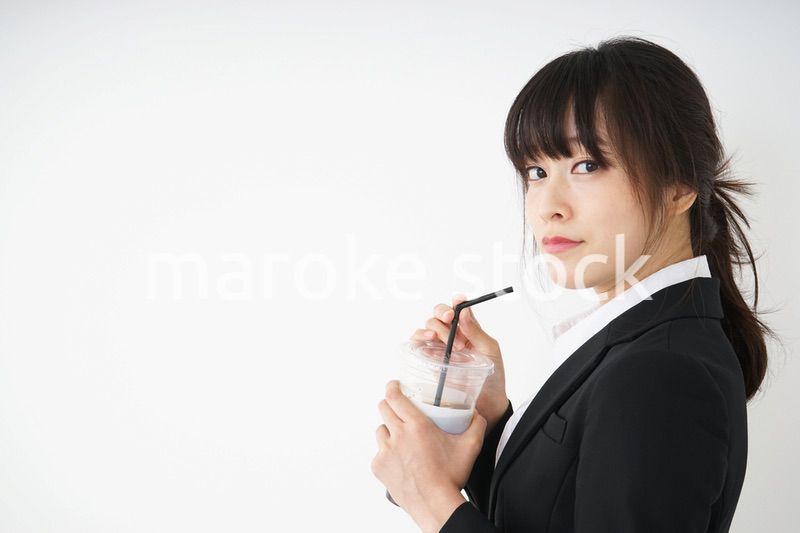 オフィスでアイスコーヒーを飲む若いビジネスウーマン