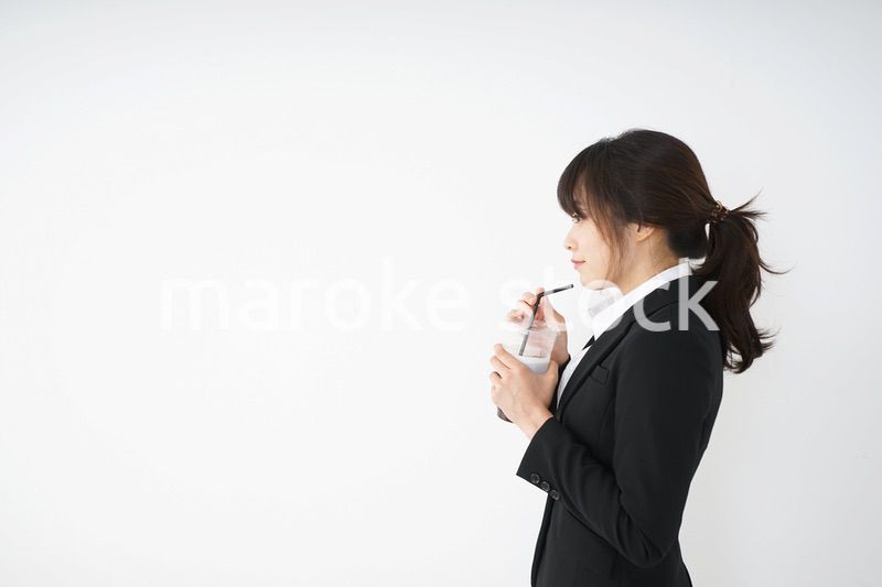 オフィスでアイスコーヒーを飲む若いビジネスウーマン