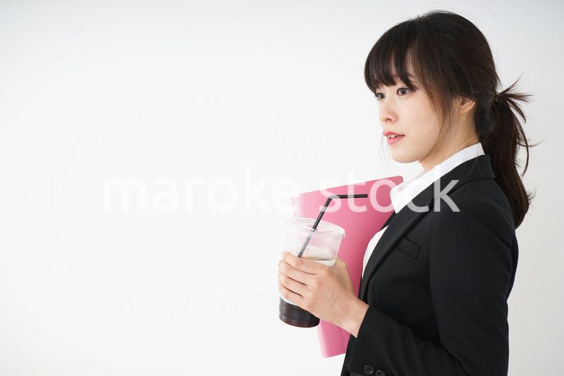 オフィスでアイスコーヒーを飲む若いビジネスウーマン