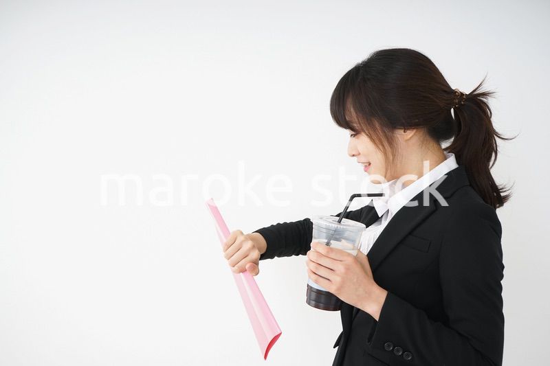 オフィスでアイスコーヒーを飲む若いビジネスウーマン