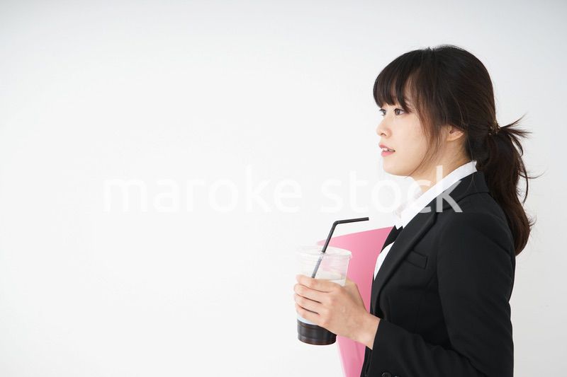 オフィスでアイスコーヒーを飲む若いビジネスウーマン