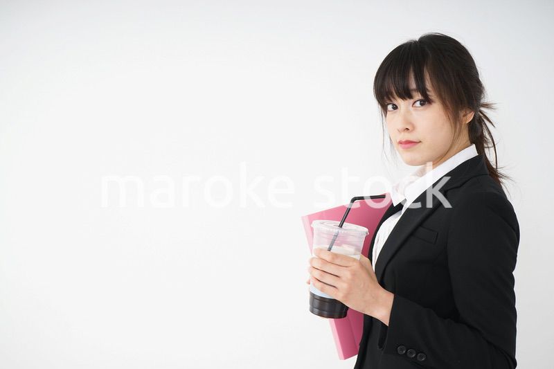 オフィスでアイスコーヒーを飲む若いビジネスウーマン
