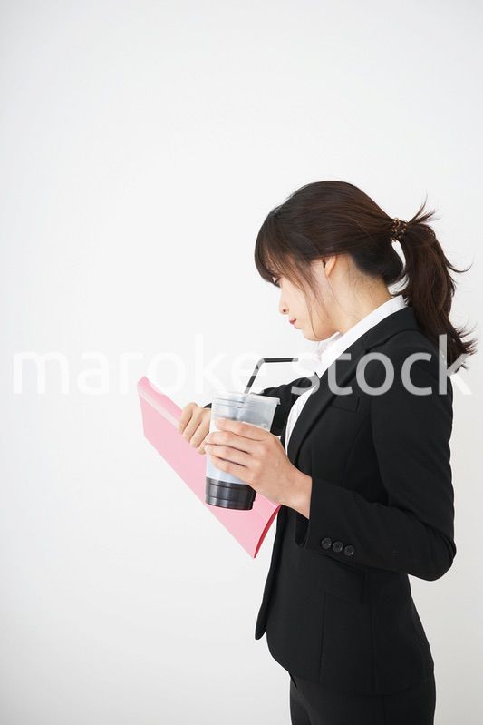 オフィスでアイスコーヒーを飲む若いビジネスウーマン