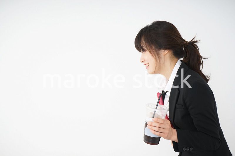 オフィスでアイスコーヒーを飲む若いビジネスウーマン