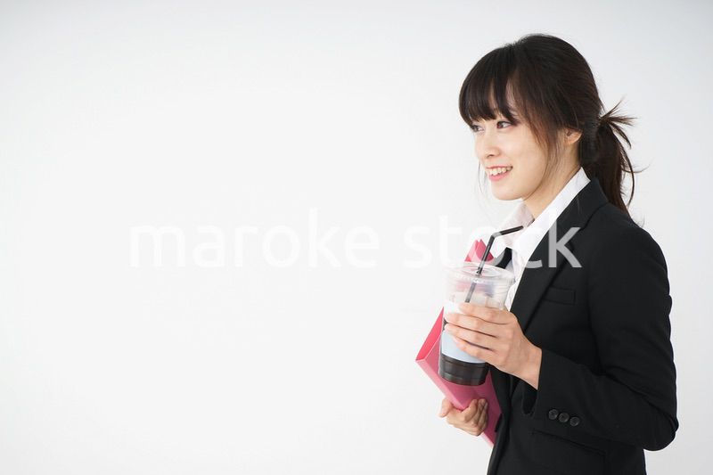 オフィスでアイスコーヒーを飲む若いビジネスウーマン
