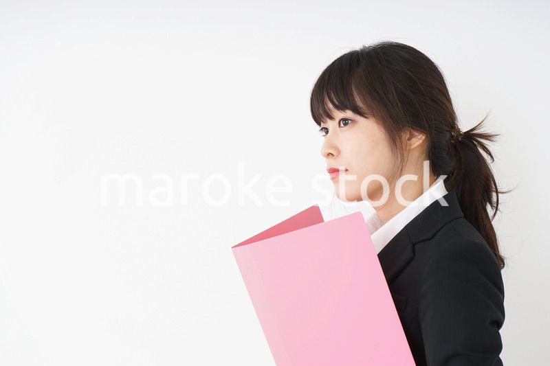 オフィスで書類を持つ若い女性