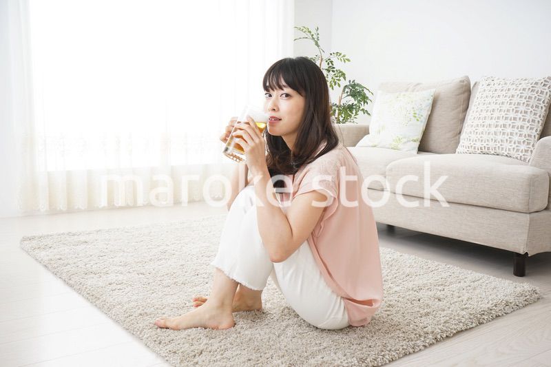 自宅でビールを飲む若い女性