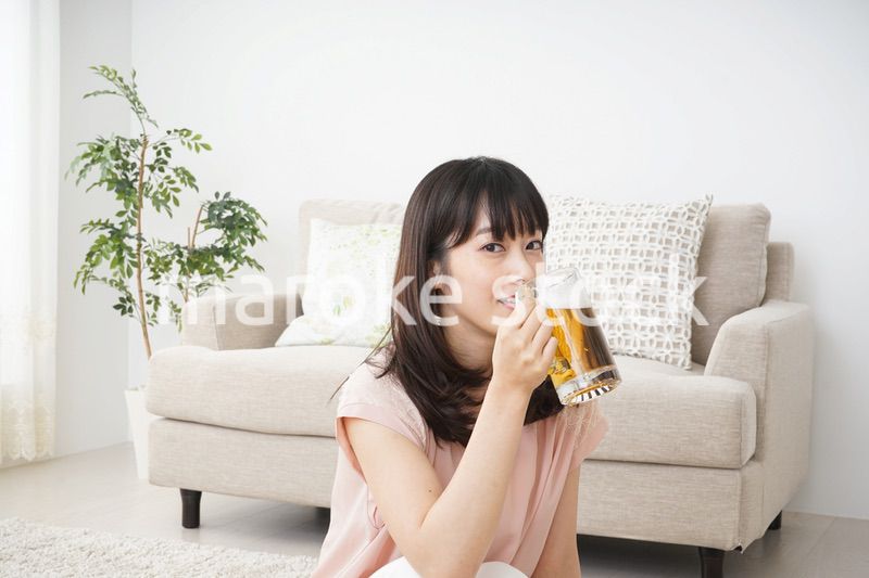 自宅でビールを飲む若い女性