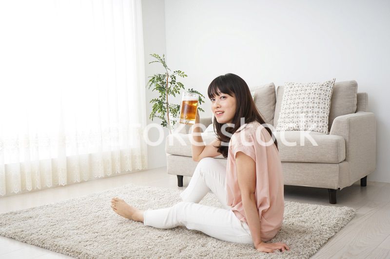 自宅でビールを飲む若い女性