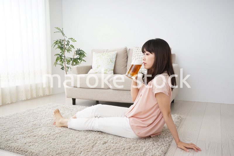 自宅でビールを飲む若い女性