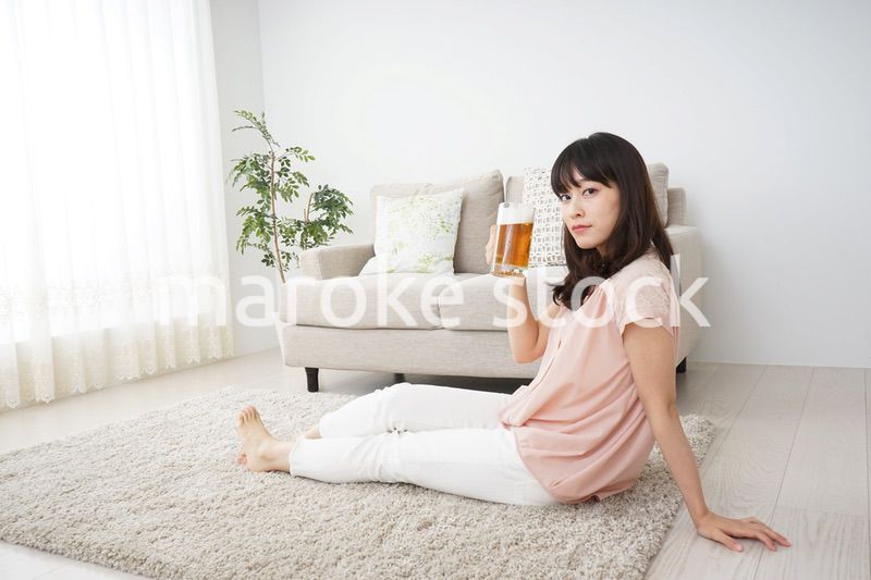 自宅でビールを飲む若い女性
