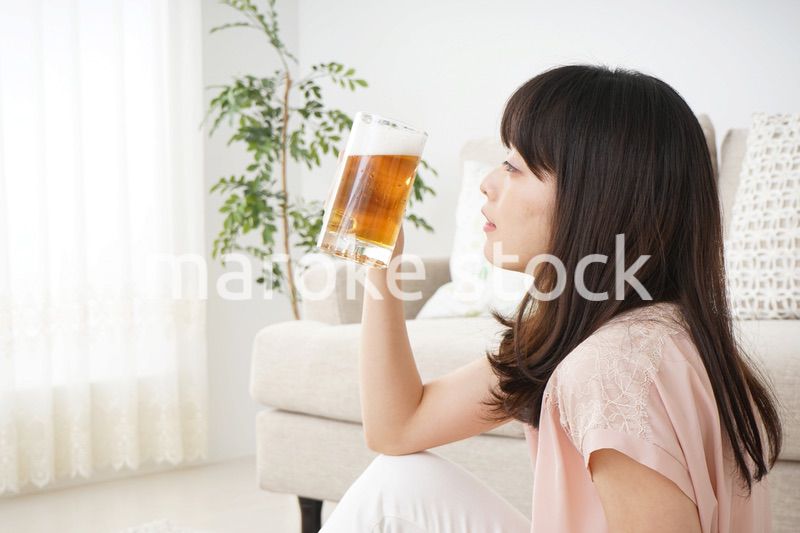 自宅でビールを飲む若い女性