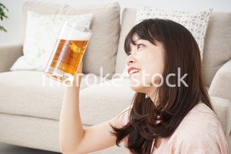 自宅でビールを飲む若い女性