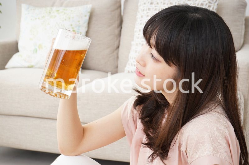自宅でビールを飲む若い女性