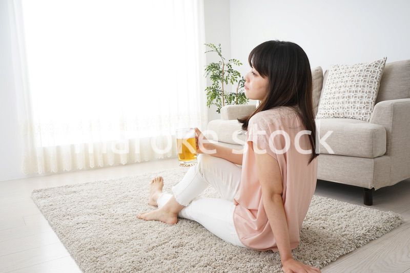 自宅でビールを飲む若い女性