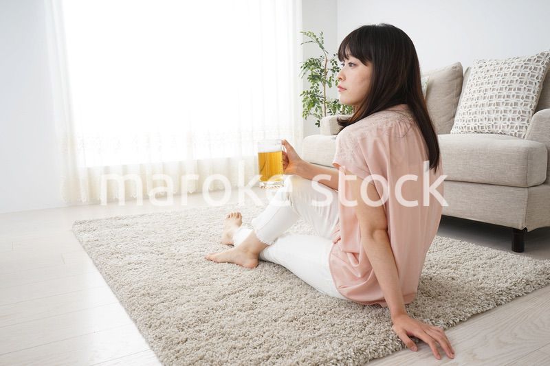 自宅でビールを飲む若い女性