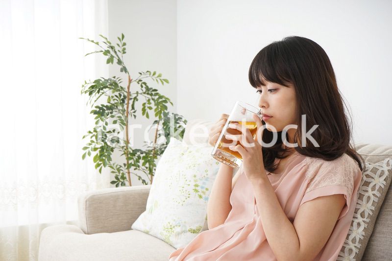 自宅でビールを飲む若い女性