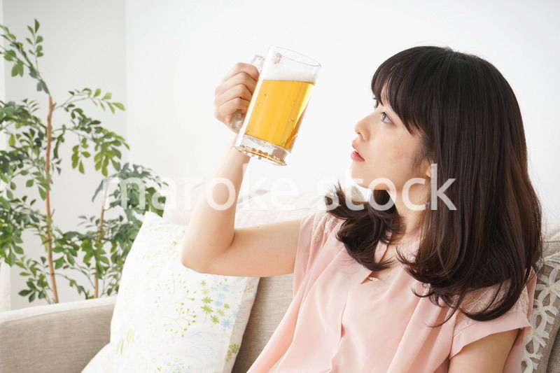 自宅でビールを飲む若い女性
