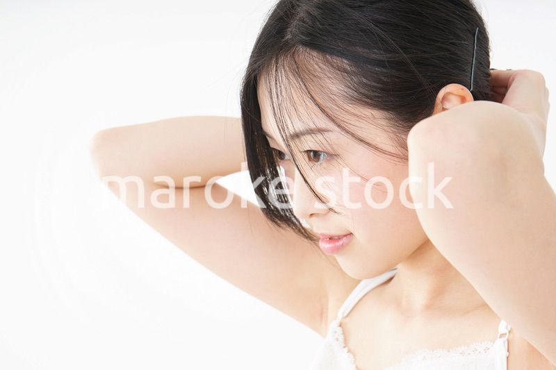 髪の毛をセットする若い女性