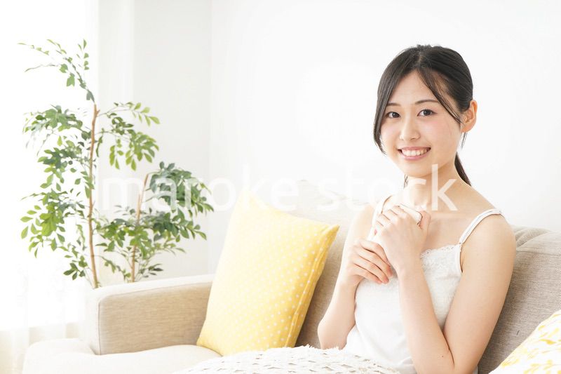 部屋でスマホを使う若い女性