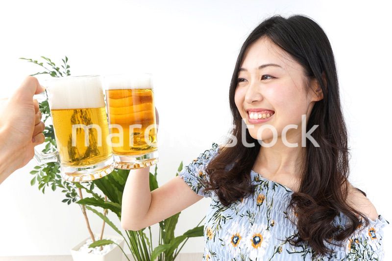 ビアガーデンでビールを飲む若い女性