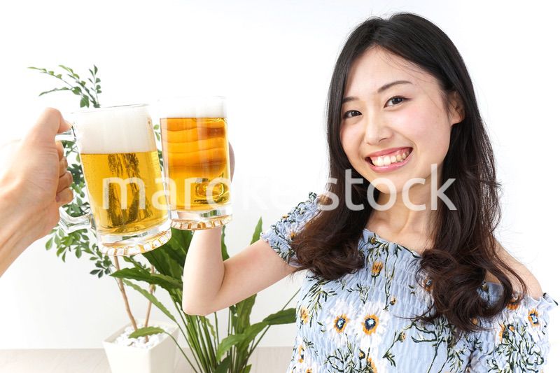 ビアガーデンでビールを飲む若い女性