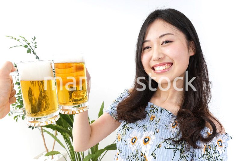 ビアガーデンでビールを飲む若い女性