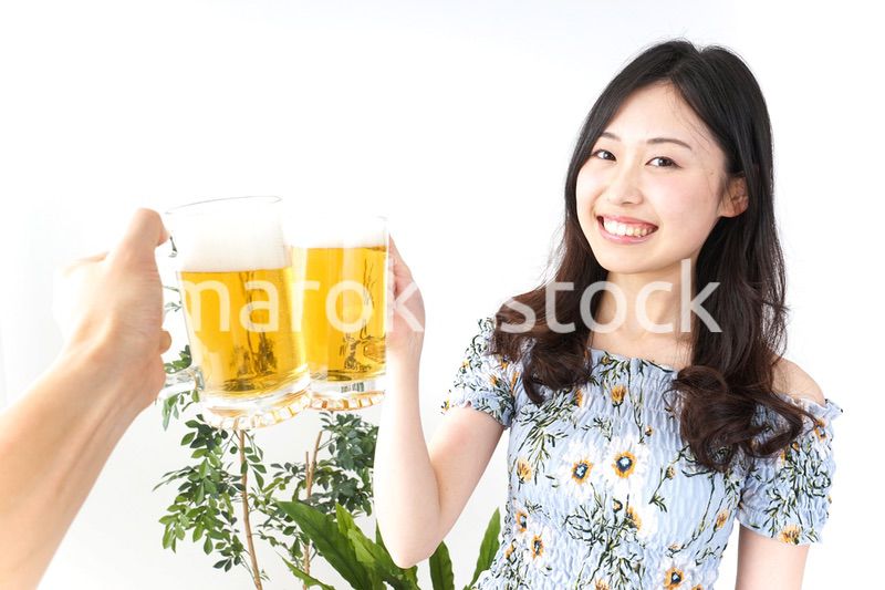 ビアガーデンでビールを飲む若い女性