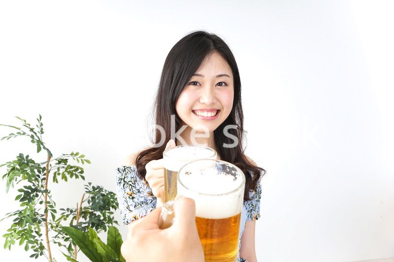 ビアガーデンでビールを飲む若い女性