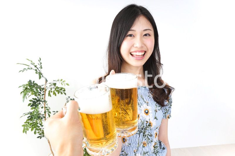 ビアガーデンでビールを飲む若い女性