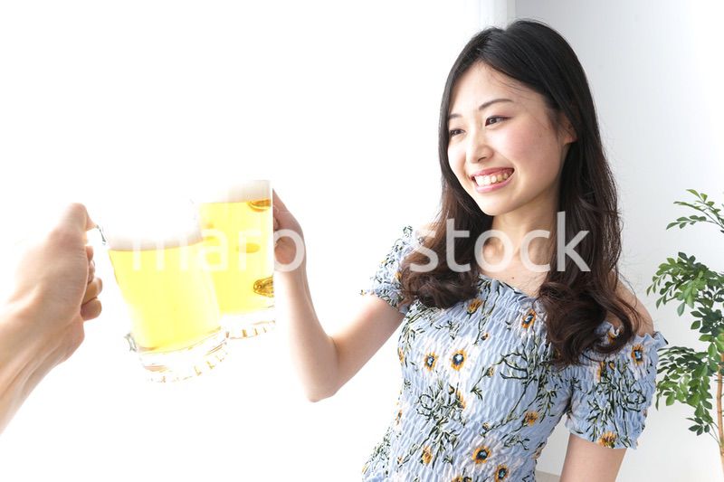 ビアガーデンでビールを飲む若い女性