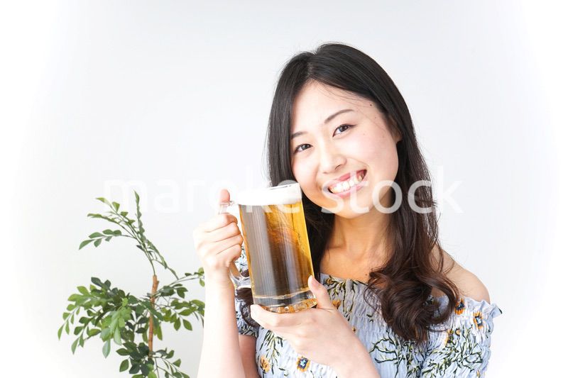 ビアガーデンでビールを飲む若い女性