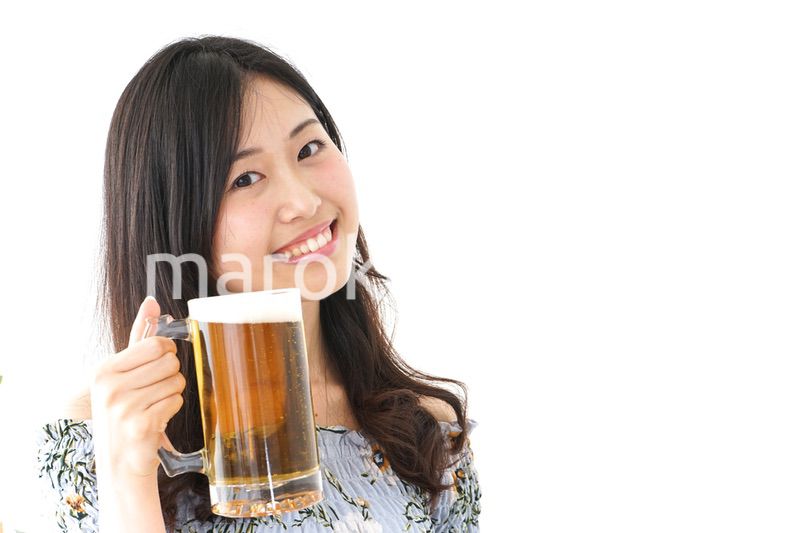 ビアガーデンでビールを飲む若い女性