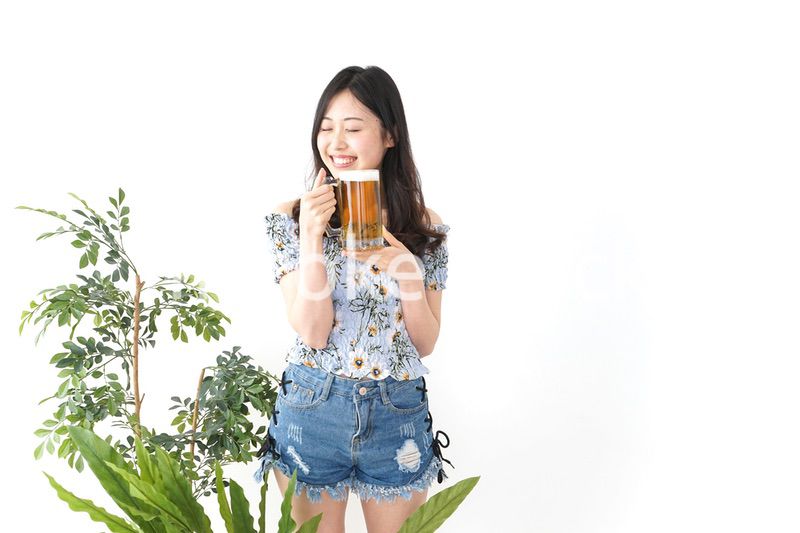 ビアガーデンでビールを飲む若い女性