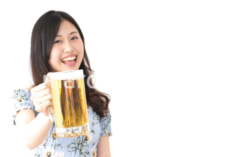 ビアガーデンでビールを飲む若い女性
