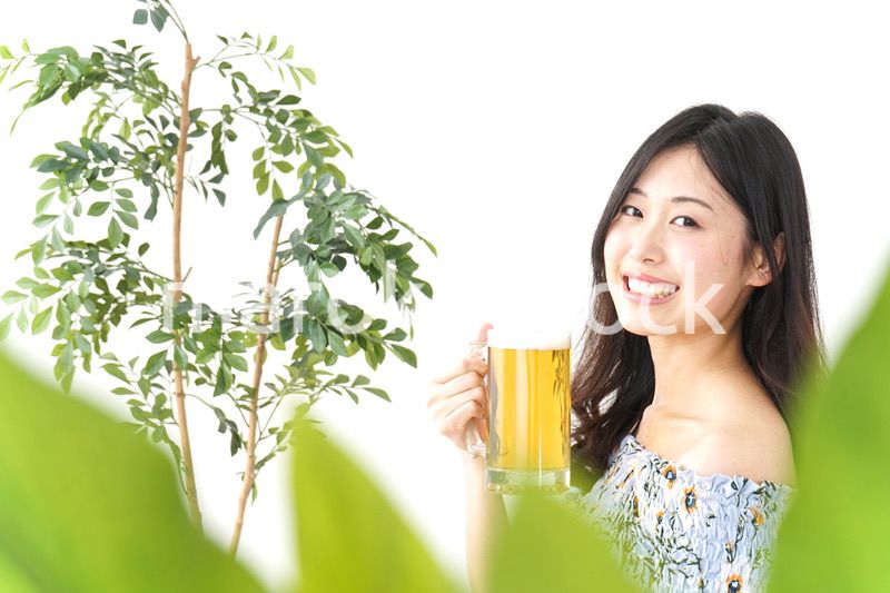 ビアガーデンでビールを飲む若い女性